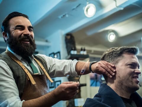 Smilende barber og kunde